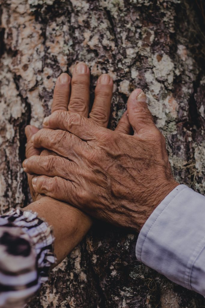 Twee verstrengelde handen die elkaar stevig vasthouden, symboliserend de intieme en ondersteunende relatie tussen partners.